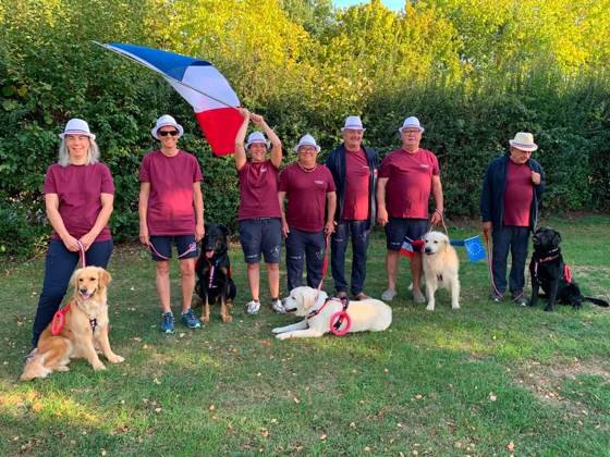 La délégation française, drapeau tricolore, avec ses chiens
